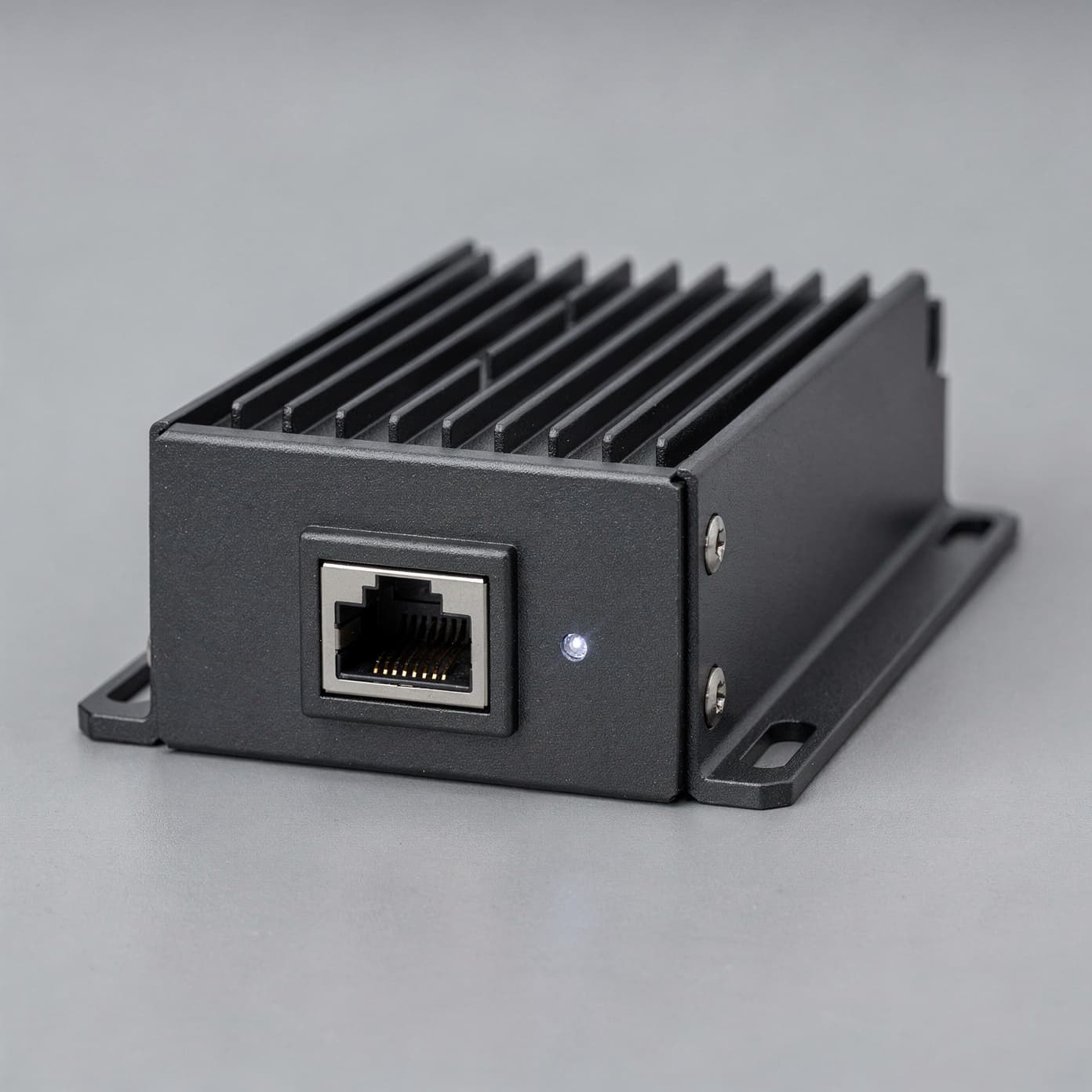Matte anthracite Tessure Fusion Node edge appliance on a neutral grey studio backdrop, showing heatsink fins and a front-mounted RJ45 port